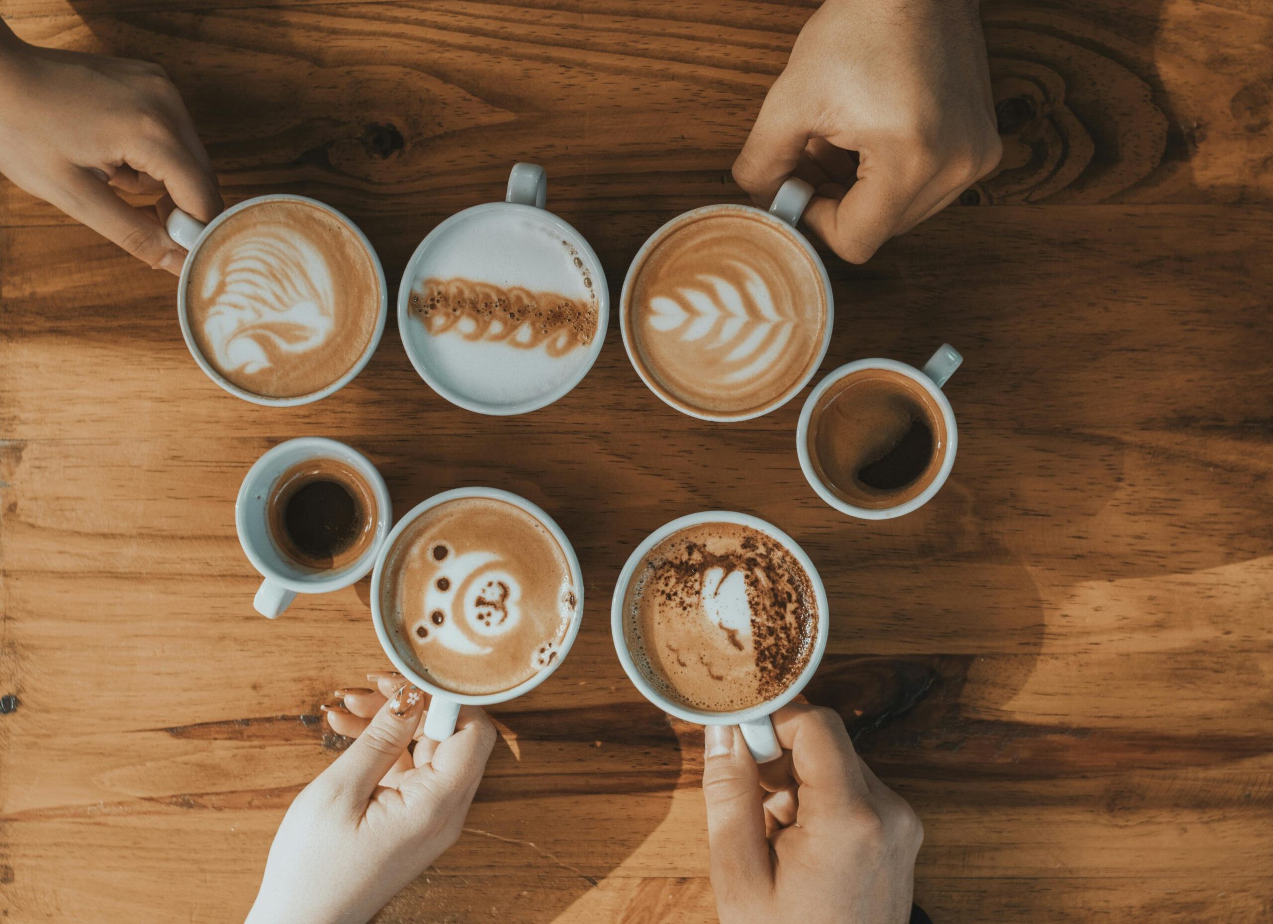 Hände, die Kaffeetassen halten
